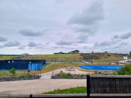 Blick auf einen Park mit 2 Tennisplätzen in der Unterkunft Cape Family Getaway in Cape Paterson