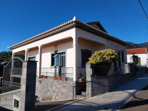 a white house with a fence in front of it at Casa do Vale da Estrela in Calheta