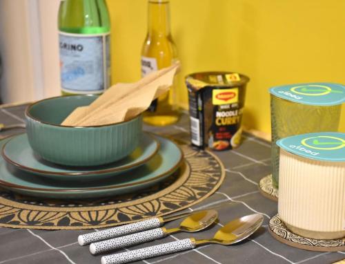 a counter top with a bowl and plates and spoons at UrbanJungle-Studio σε ξέφωτο μες στην πόλη in Patra