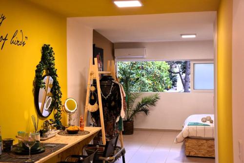 a room with yellow walls and a desk with a mirror at UrbanJungle-Studio σε ξέφωτο μες στην πόλη in Patra