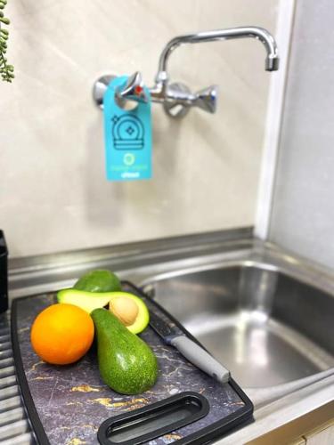 a cutting board with fruit on top of a sink at UrbanJungle-Studio σε ξέφωτο μες στην πόλη in Patra