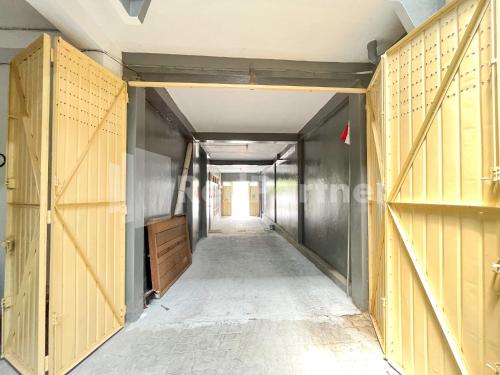 a corridor of an empty room with wooden doors at Homestay & Cafe Blessings Near Station Center Town RedPartner in Kediri