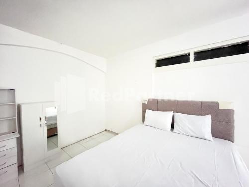 ein weißes Schlafzimmer mit einem Bett und einem Spiegel in der Unterkunft Blessing Syariah Homestay Kediri RedPartner in Kediri