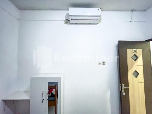 a room with a door and a heater on the wall at Homestay & Cafe Blessings Near Station Center Town RedPartner in Kediri