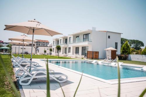 a swimming pool with lounge chairs and an umbrella at Apartments Antique in Ulcinj