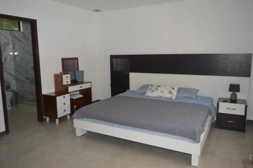 a bedroom with a bed and a dresser and a mirror at Quinta Rousse in Santa Isabel