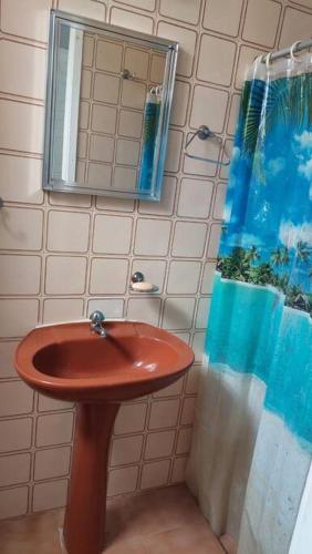 a bathroom with a sink and a mirror at Casa da Vovó Irene in Araruama