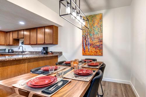 una cucina e una sala da pranzo con tavolo e piatti rossi di PARK STATION 133 condo a Park City