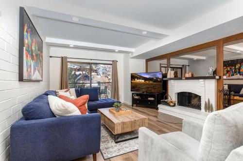 un soggiorno con un divano blu e un camino di PARK STATION 133 condo a Park City