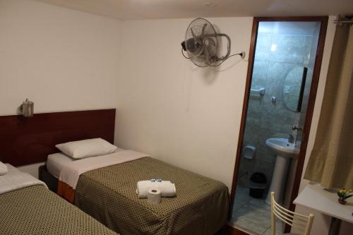 a small bedroom with two beds and a shower at COPACABANA in Lima