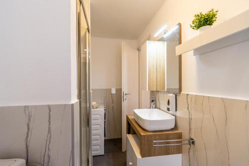ein Bad mit einem Waschbecken und einem WC in der Unterkunft Golden Lake - Luxury Apartment ☆☆☆☆☆ - 100m from the lake in Baveno
