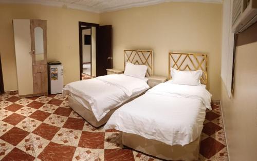 1 dormitorio con 2 camas con sábanas blancas en فندق وسط البلد en Riad