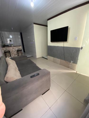 a living room with a couch and a flat screen tv at Hoje Apartamentos in Feira de Santana