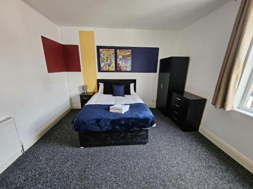 a bedroom with a bed with a blue comforter at Cannon Hill Shared House in Birmingham