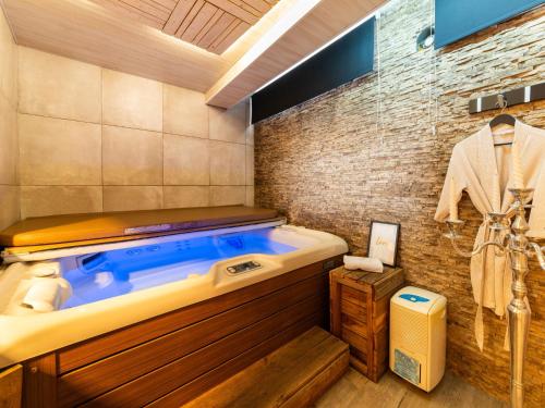 a bath tub in a bathroom with a brick wall at Magnificent home with jacuzzi in La Calamine