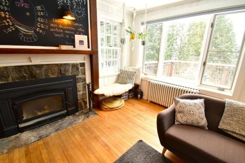 a living room with a fireplace and a couch at Le Partage Lodge: Destination plein air et sociale in Val-Morin