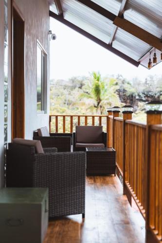 a porch with wicker chairs and a wooden deck at German Home Tobias in Bahía de la Academia