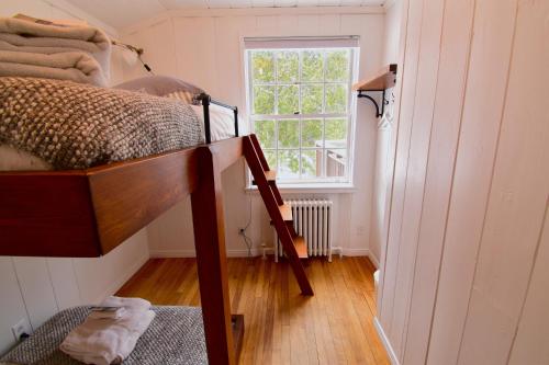 Val-MorinにあるLe Partage Lodge: Destination plein air et socialeの二段ベッド1組と窓が備わる客室です。