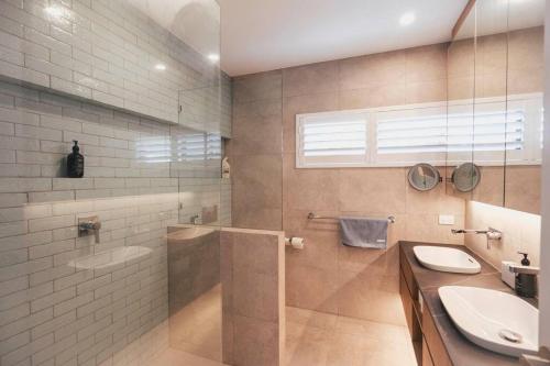 Un baño con ducha, lavabo e inodoro. en Sunset Lagoon ~ Noosa Luxury with Stunning Views, en Noosa Heads