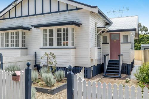 a white house with a fence in front of it at Camellia Cottage! CBD Diamond! in Toowoomba