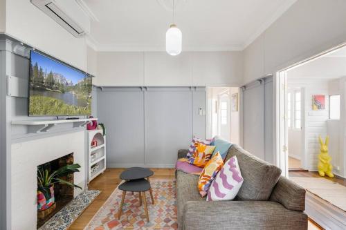 a living room with a couch and a fireplace at Camellia Cottage! CBD Diamond! in Toowoomba