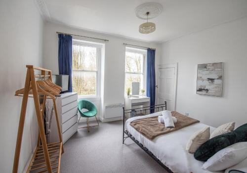 a bedroom with a bed and a desk and two windows at Grosvenor Pad - Lovely 2-bed Flat - FREE ON STREET PARKING in Bath