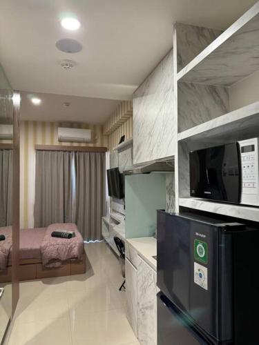 a small room with a kitchen with a tv and a room with at CitraPlaza Nagoya #32 cozy (WI-Fi) in Jodoh