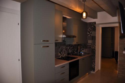 a kitchen with white cabinets and a sink at Bramante Suites Urbino in Urbino