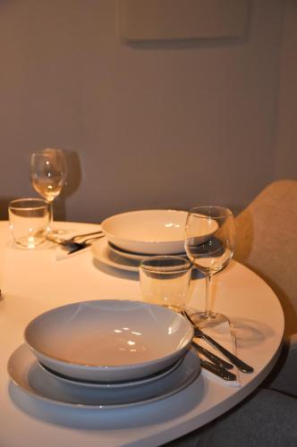 a table with white plates and wine glasses on it at Bramante Suites Urbino in Urbino