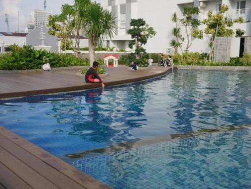 a boy sitting in the water in a swimming pool at CitraPlaza Nagoya #32 cozy (WI-Fi) in Jodoh