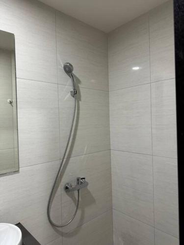 a shower in a bathroom with a sink at CitraPlaza Nagoya #32 cozy (WI-Fi) in Jodoh