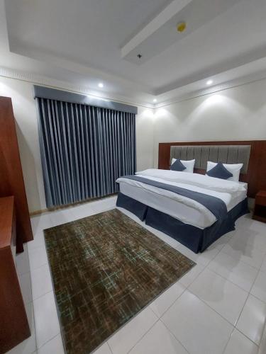 a bedroom with a large bed and a rug at شقق القارات السبع المخدومة in Medina
