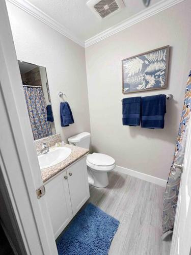a bathroom with a toilet and a sink with blue towels at Spacious South Bay Condo in Torrance