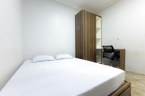 una camera da letto con un letto bianco e uno specchio di D Twinz House Syariah Redpartner a Tangerang