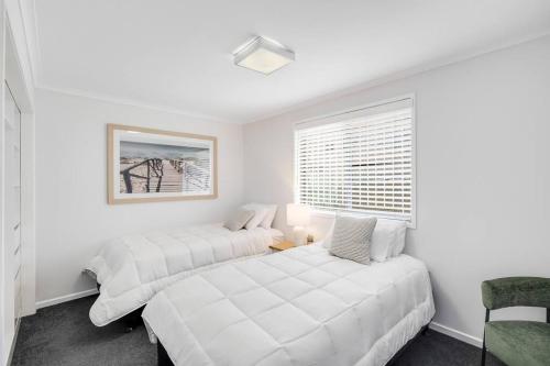two beds in a white room with a window at So Central, So Comfortable! in Toowoomba