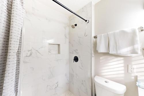 a white bathroom with a shower and a toilet at Orange Oasis in Atlanta