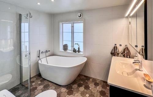 Baño blanco con bañera y lavamanos en 3 Bedroom Lovely Home In Alingss en Alingsås