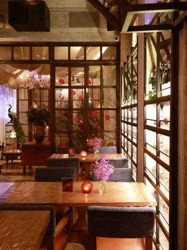 a restaurant with a table and chairs and a room with windows at At Niman conceptual Home chiangmai in Chiang Mai