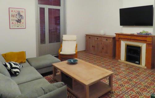 un salon avec un canapé et une télévision dans l'établissement Nice Home In Faugères, à Faugères