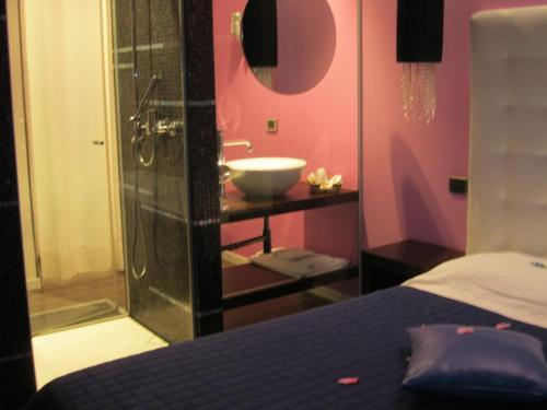a bathroom with a sink and a bed and a sink at Hotel In - Lounge Room in Cazzago di Pianiga