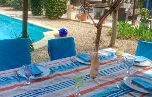 - une table avec des assiettes et des verres à côté de la piscine dans l'établissement Nice Home In Lorgues With Wifi, à Lorgues