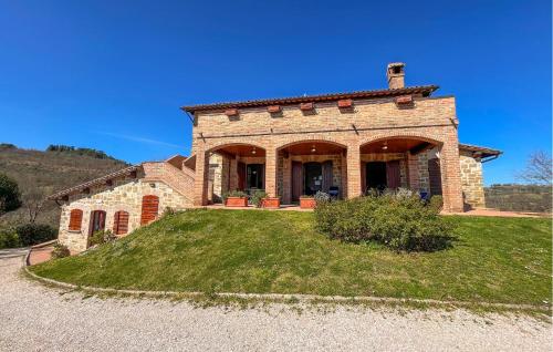 a brick house on a grassy hill at Stunning Apartment In Gubbio With Wifi in Gubbio