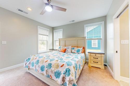 a bedroom with a bed and a nightstand and two windows at Millville by the Sea --- 36515 Calm Water Dr in Millville