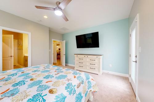 a bedroom with a bed and a flat screen tv at Millville by the Sea --- 36515 Calm Water Dr in Millville