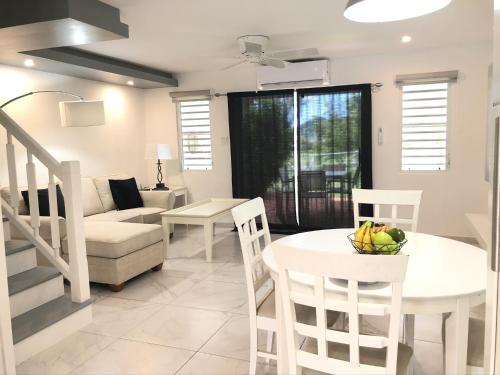 a white living room with a table and a couch at 101E Jolly Harbour in Jolly Harbour