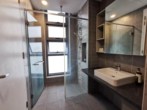 a bathroom with a sink and a glass shower at The Robertson Residences at Bukit Bintang Kuala Lumpur by Autumn Suites Premium Stay in Kuala Lumpur