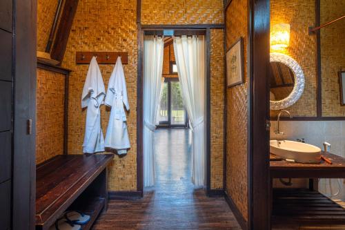 a bathroom with a tub and a sink and a mirror at Samawa Seaside Resort in Sumbawa Besar