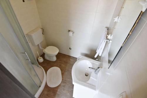 a small bathroom with a toilet and a sink at Family-friendly apartments with swimming pool Tar, Porec - 22756 in Tar