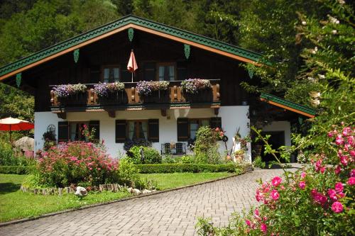 a house with flowers in front of it at Ferienwohnung Hinterreiter inkl. Chiemgaukarte in Ruhpolding