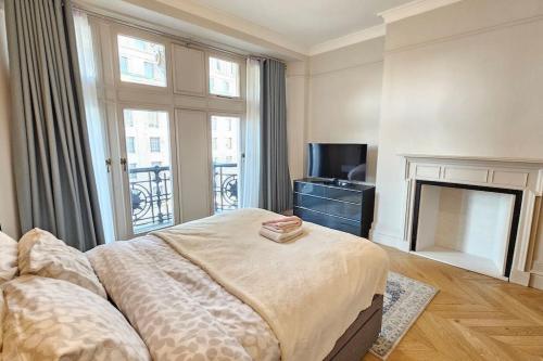 a bedroom with a bed and a fireplace and a television at Apartment London Eye& Big Ben.Walk to China Town.Oxford street in London